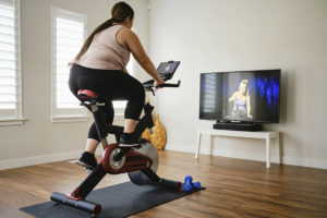 女子在室内运动自行车上使用数字健身